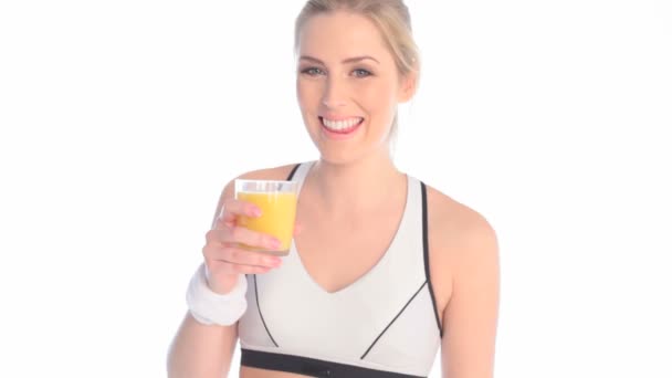 Улыбающаяся спортсменка пьет свежий апельсиновый сок — стоковое видео