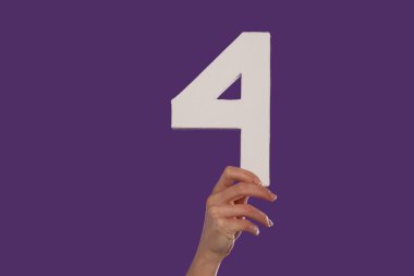 Female hand holding up the number 4 from the bottom