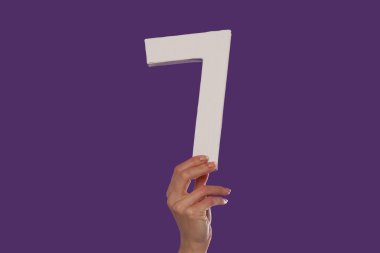 Female hand holding up the number 7 from the bottom clipart