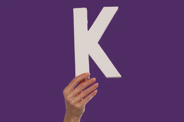 Female hand holding up the letter K from the bottom — Stock Photo, Image