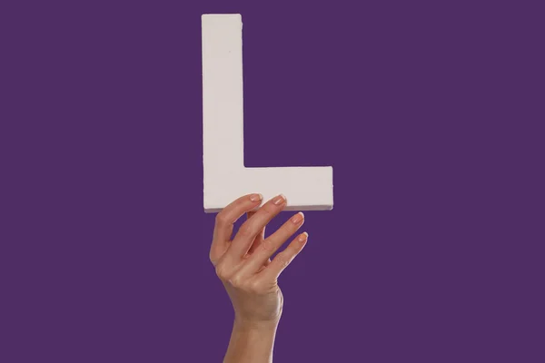 Kvinnlig hand som håller upp den bokstav l från botten — Stockfoto