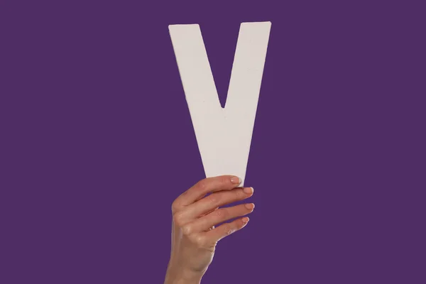 Main féminine tenant la lettre V du bas — Photo