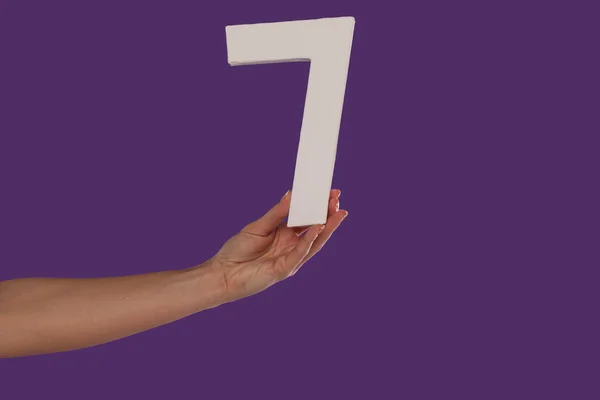 Female hand holding up the number 7 from the left — Stock Photo, Image