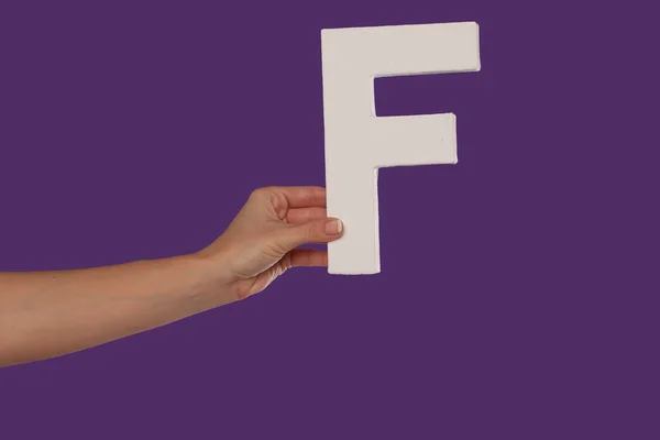 Female hand holding up the letter F from the left — Stock Photo, Image