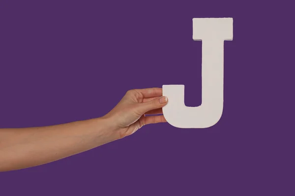 Female hand holding up the letter J from the left — Stock Photo, Image