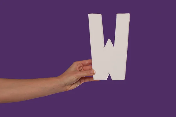 Γυναικείο χέρι που κρατά ψηλά το γράμμα w από αριστερά — Φωτογραφία Αρχείου