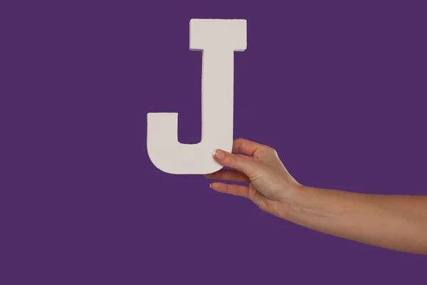 Mano femenina sosteniendo la letra J desde la derecha — Foto de Stock