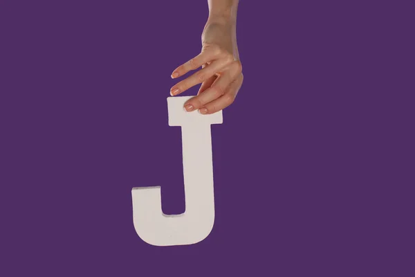 Γυναικείο χέρι που κρατά μέχρι το γράμμα j από την κορυφή — Φωτογραφία Αρχείου