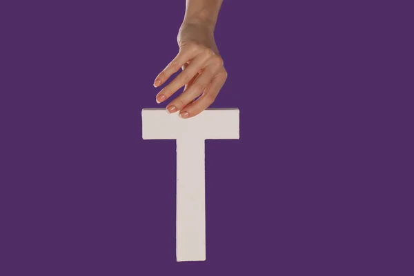 Female hand holding up the letter T from top — Stock Photo, Image