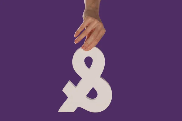 Female hand holding up an ampersand from the top — Stock Photo, Image