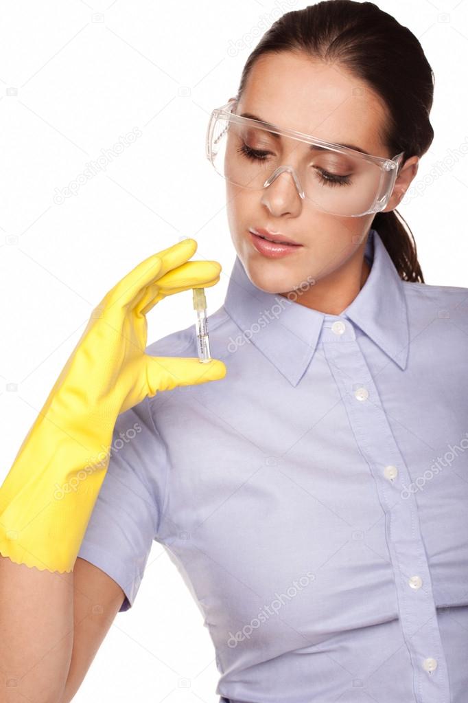 Beautiful female medical technologist or laboratory technician looking at a specimen in a test tube isolated on white