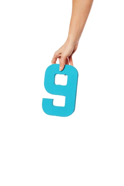Ręka trzyma numer dziewięć z góry — Zdjęcie stockowe