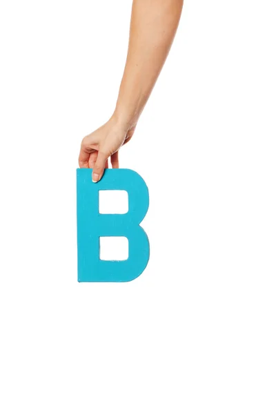 Mão segurando a letra B a partir do topo — Fotografia de Stock