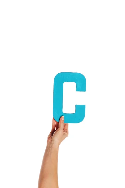 Mão segurando a letra C a partir do fundo — Fotografia de Stock