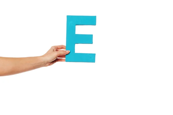 Hand som håller upp den bokstaven e från vänster — Stockfoto