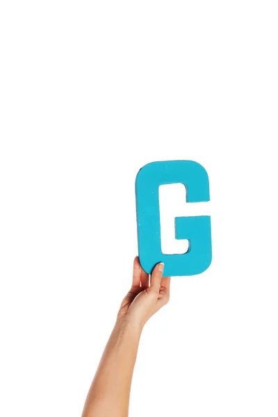 Hand, die den Buchstaben g von unten hochhält — Stockfoto