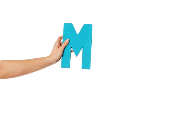Hand holding up the letter M from the left — Stock Photo, Image