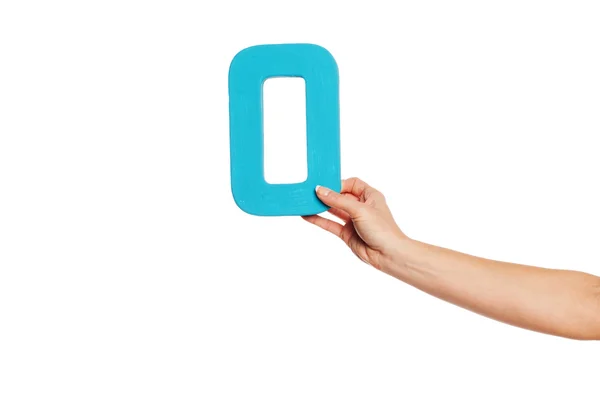 Hand holding up the letter O from the right — Stock Photo, Image