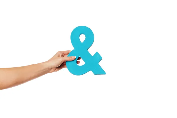 Hand holding up an ampersand from the left — Stock Photo, Image