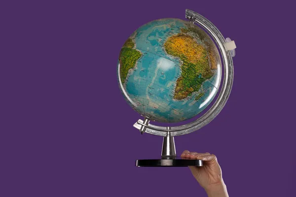 Main féminine avec un globe — Photo