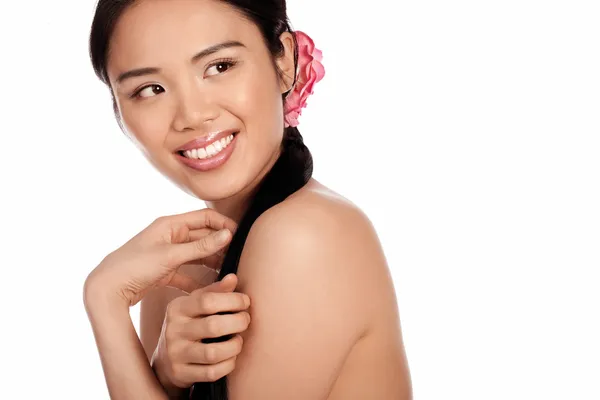 Hermosa mujer asiática con una flor en el pelo — Foto de Stock