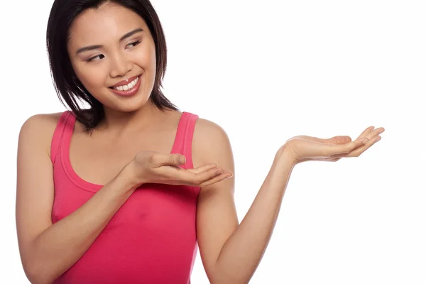 Sorridente donna asiatica tenendo fuori il palmo della mano — Foto Stock