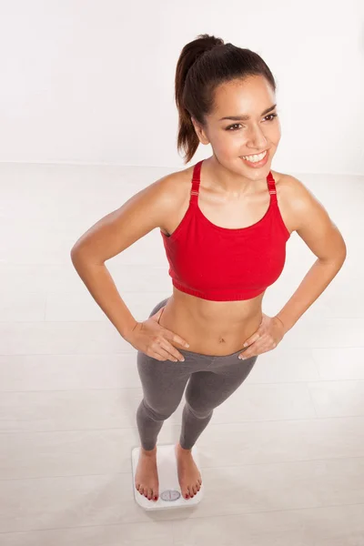 Smiling happy woman on a bathroom scale — Stock Photo, Image