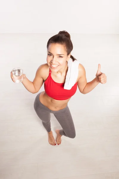 Woman drinking water giving a thumbs up — Stock Photo, Image