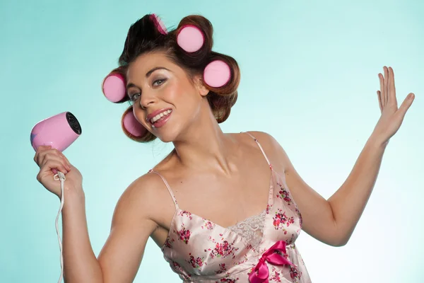 Woman in haircurlers with hairdryer — Stock Photo, Image