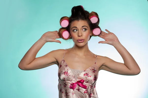 Invano bella giovane donna mostrando i suoi rulli per capelli — Foto Stock