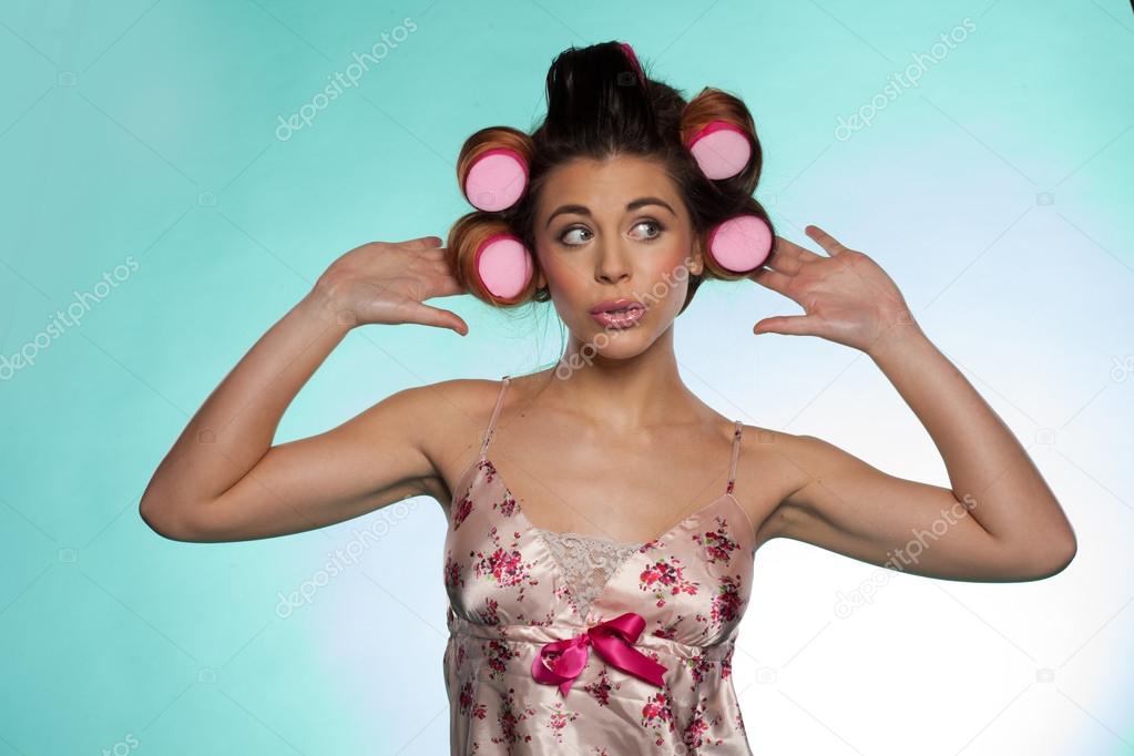 Vain pretty young woman showing her hair rollers