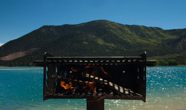 Grillning tæt på et landskab af bjerge og hav - Stock-foto