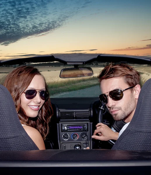 Happy smiling couple in a convertible car. People outdoors. — Stock Photo, Image