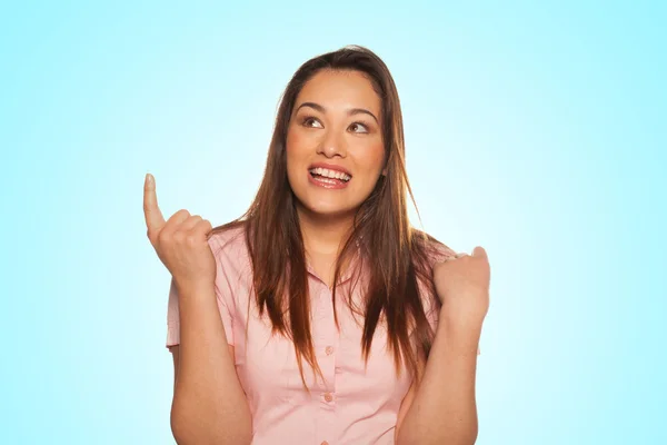 Portrait of smiling young woman pointing up — Stock Photo, Image