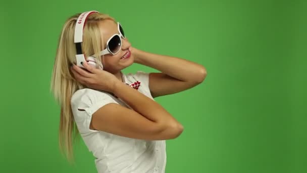 Schöne blonde Frau trägt Kopfhörer — Stockvideo
