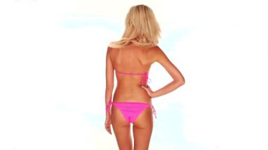 çekici genç bir kadın pembe bikini beyaz arka plan üzerinde dans etmek.