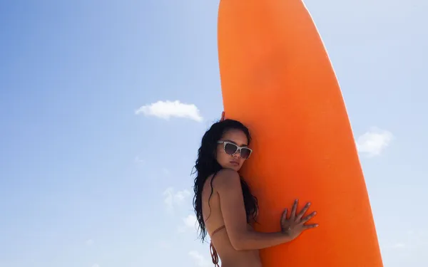 Surfermädchen posiert mit ihrem Surfbrett am Strand — Stockfoto