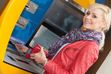 bir banka atm kullanarak gülümseyen güzel kadın