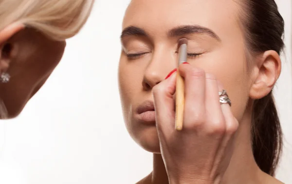 Esteticista aplicando maquillaje de ojos — Foto de Stock