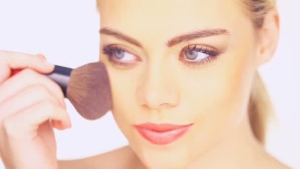 Mujer aplicando colorete con un cepillo de cosméticos — Vídeo de stock