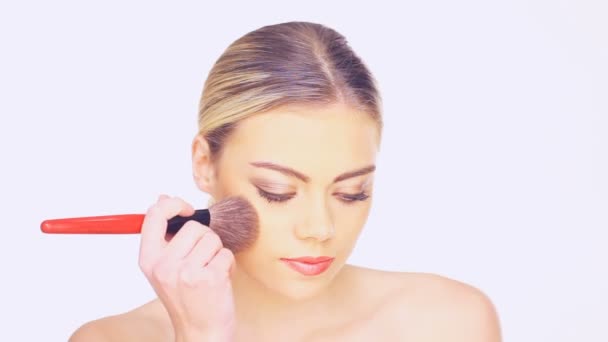 Mulher aplicando blusher com uma escova de cosméticos — Vídeo de Stock