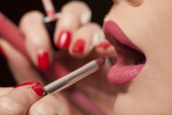 Esteticista aplicando lápiz labial a un modelo — Foto de Stock