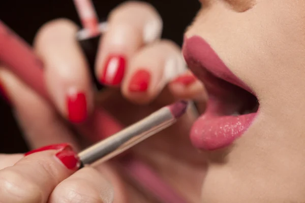Schoonheidsspecialiste lippenstift op een model toe te passen — Stockfoto