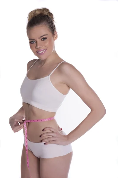 Sexy jovem mulher medindo sua cintura, em branco — Fotografia de Stock