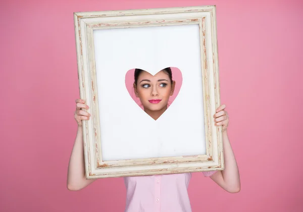 Vrouw met een triest gezicht op zoek door middel van een hart — Stockfoto