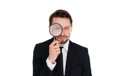 Businessman looking through a magnifying glass clipart