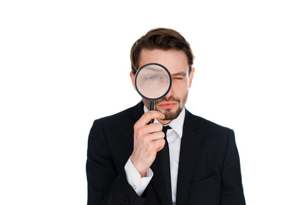 Businessman looking through a magnifying glass