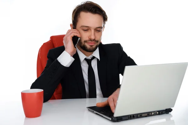 Businessman talking on his mobile at his desk — Stock Photo, Image
