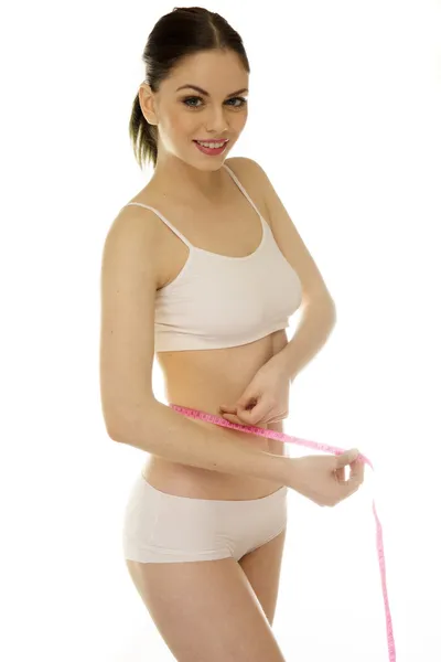 Mulher com forma esbelta medindo sua cintura — Fotografia de Stock