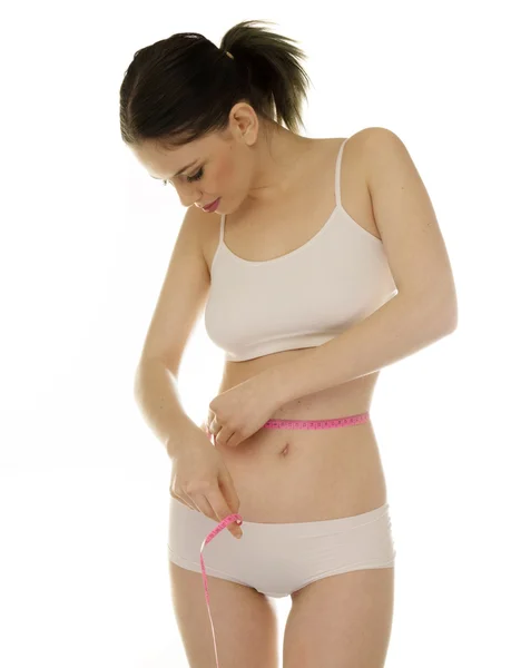 Slender young woman measuring her waist — Stock Photo, Image